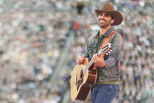 Mitch Rossell on stage playing guitar